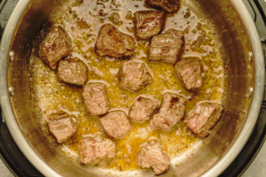 Chunks of lamb, or beef, browning in a pressure cooker for Moroccan harira soup