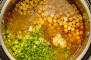 Pureed tomatoes, onion, celery, chickpeas, parsley, and cilantro in pressure cooker for Moroccan harira soup