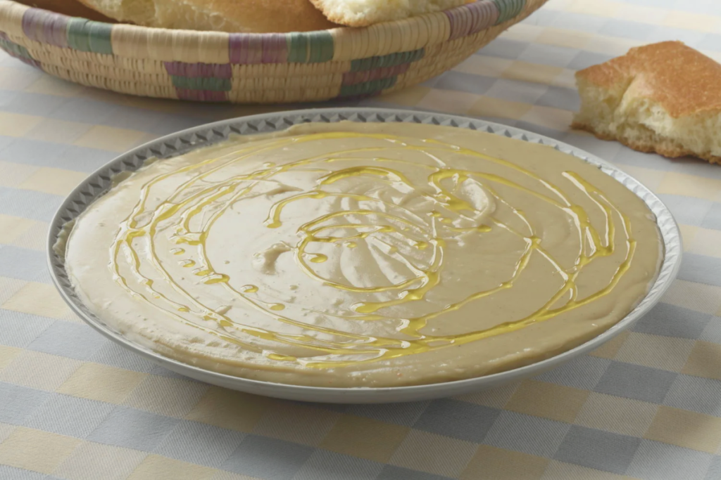 Serving Moroccan Bissara soup with olive oil, cumin, and cayenne garnish